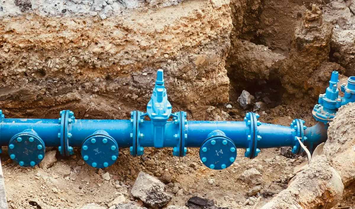 A flanged pipeline with valves being installed in an excavated trench