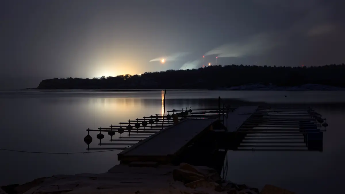 The glow of a refinery complex at night seen across the water